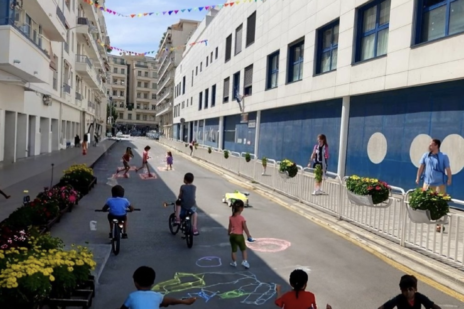 Photo de la rue des Potiers modifiée par intelligence artificielle. Des enfants jouent et dessinent sur la rue, roulent à vélo. Des fleurs décorent la rue.